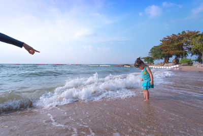 Full length of girl on beach against sky