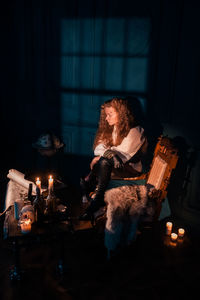 Woman sitting in illuminated room