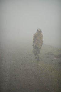 Rear view of man walking on landscape