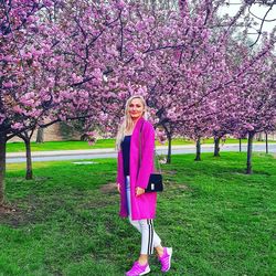 Portrait of woman with pink cherry blossoms in park