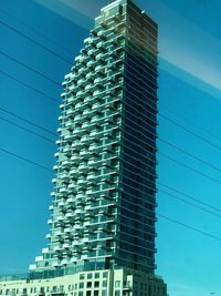 Low angle view of modern buildings against clear blue sky