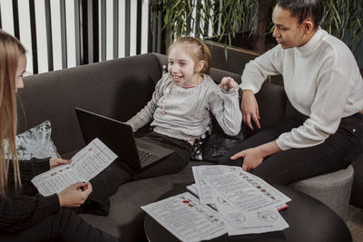 Women teaching girl at home