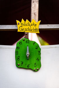 Close-up of handmade wooden clock mounted on wall