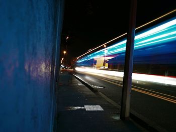 Light trails on road against sky at night