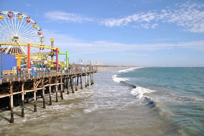 Ferris wheel at beach against sky