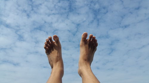 Low section of man against cloudy sky