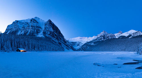 Scenic view of snowcapped mountains against clear blue sky