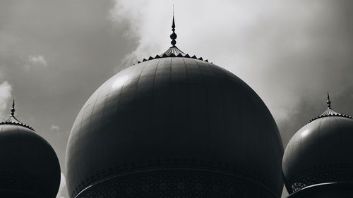 Low angle view of dome of building against cloudy sky