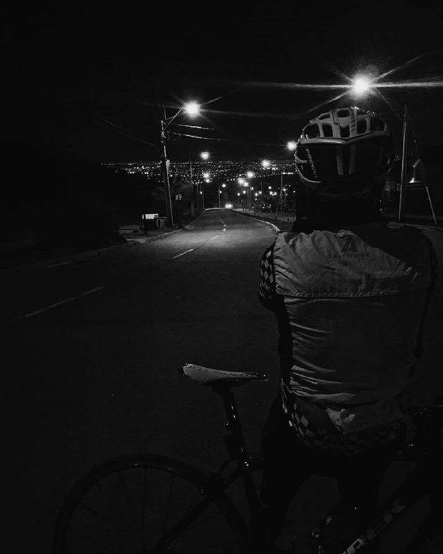 night, illuminated, transportation, bicycle, street light, street, mode of transport, land vehicle, lighting equipment, men, road, dark, lifestyles, the way forward, car, leisure activity, rear view, light - natural phenomenon