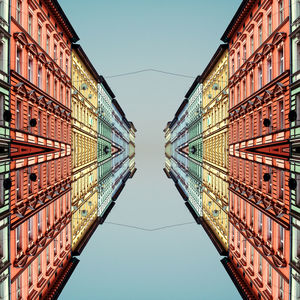 Reflection of buildings in water against clear sky