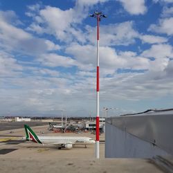 Airplane on airport runway against sky