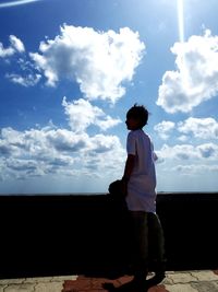 Rear view of silhouette man standing against sky