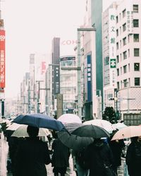 Rear view of woman with umbrella on street