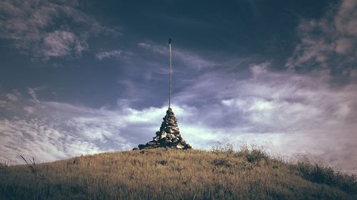 Low angle view of cross on field against sky