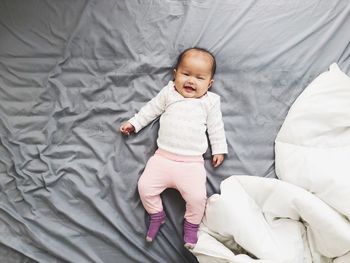 High angle view of baby lying on bed