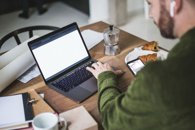 High angle view entrepreneur using laptop at home office