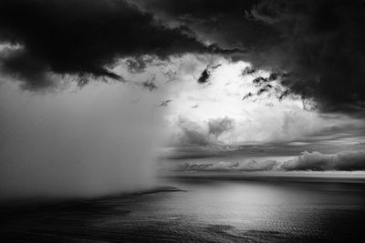 Scenic view of sea against storm clouds