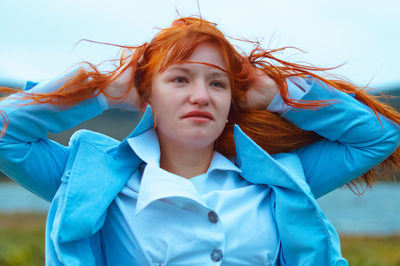 Close-up of young woman with hand behind head