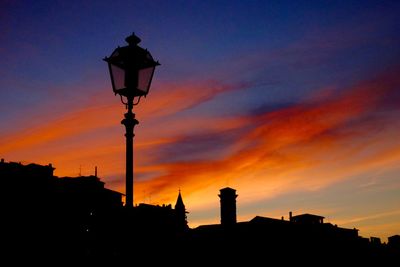 Low angle view of silhouette building against sky at sunset