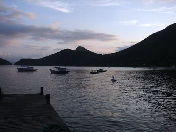 Boats in sea at sunset