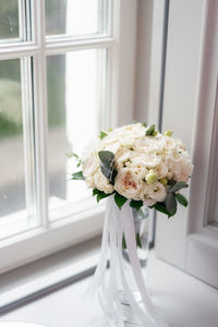 White rose flower vase on window