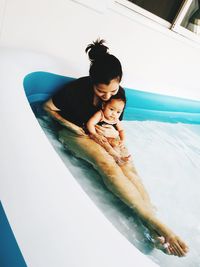 High angle view of woman relaxing in swimming pool