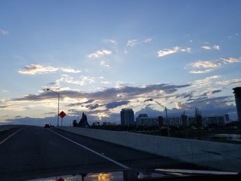 Man in city against sky during sunset