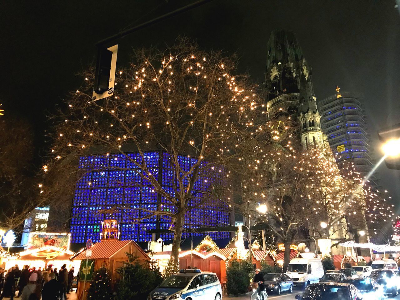 ILLUMINATED CHRISTMAS TREE IN CITY AT NIGHT