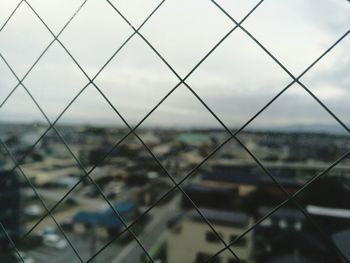 Full frame shot of chainlink fence against cloudy sky