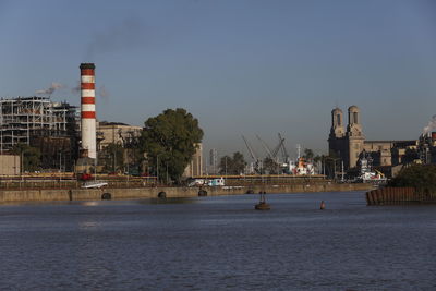 Factory by buildings against clear sky