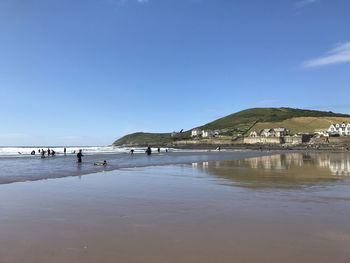 Scenic view of beach against clear blue sky and headland