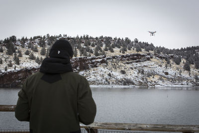 Young man flying drone above reservoir, oregon.