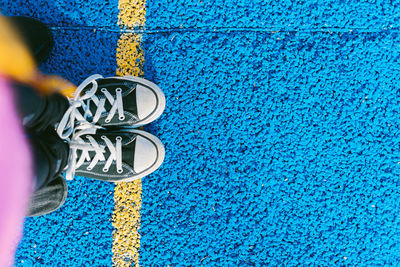 Low section of person standing against blue wall