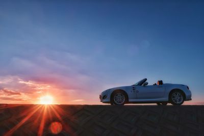 Vintage car against sky during sunset