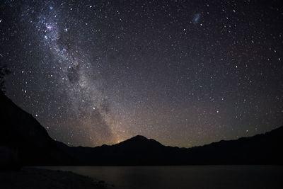 Scenic view of silhouette mountains against sky at night