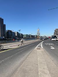 Road by buildings against sky in city