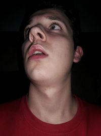 Close-up of young man against black background