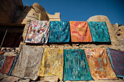 Low angle view of clothes drying on old building against sky