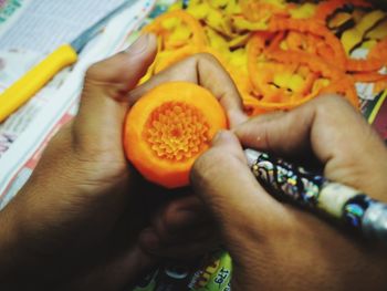 Cropped image of hand holding orange fruit