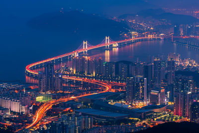 Illuminated cityscape against sky at night