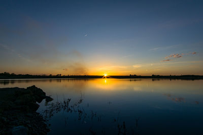 Scenic view of calm lake at sunset