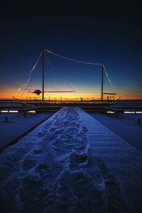 Pier in sea at sunset