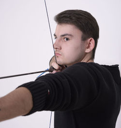 Close-up of man holding camera over white background