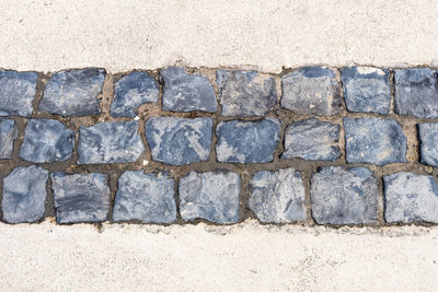 High angle view of paved footpath amidst sand