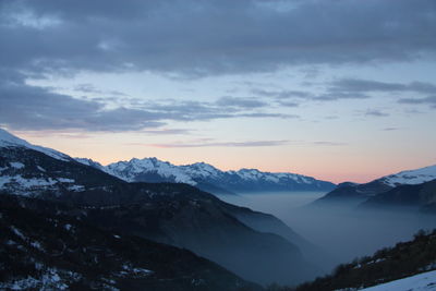 Scenic view of snowcapped mountains against sky during sunset