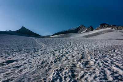 Scenic view of snowcapped mountains against clear blue sky