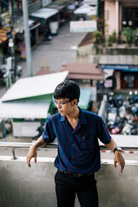 Young man looking away in city