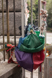 Abandoned cloths and dolls hanging on fence