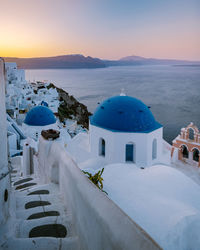 Panoramic view of sea and buildings against sky during sunset