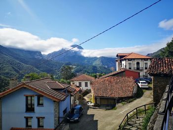 Houses by road in town against sky